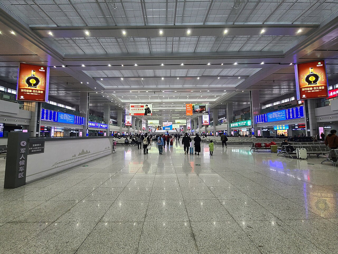 Wide waiting hall at Chongqing North railway station with seating and overhead departure displays