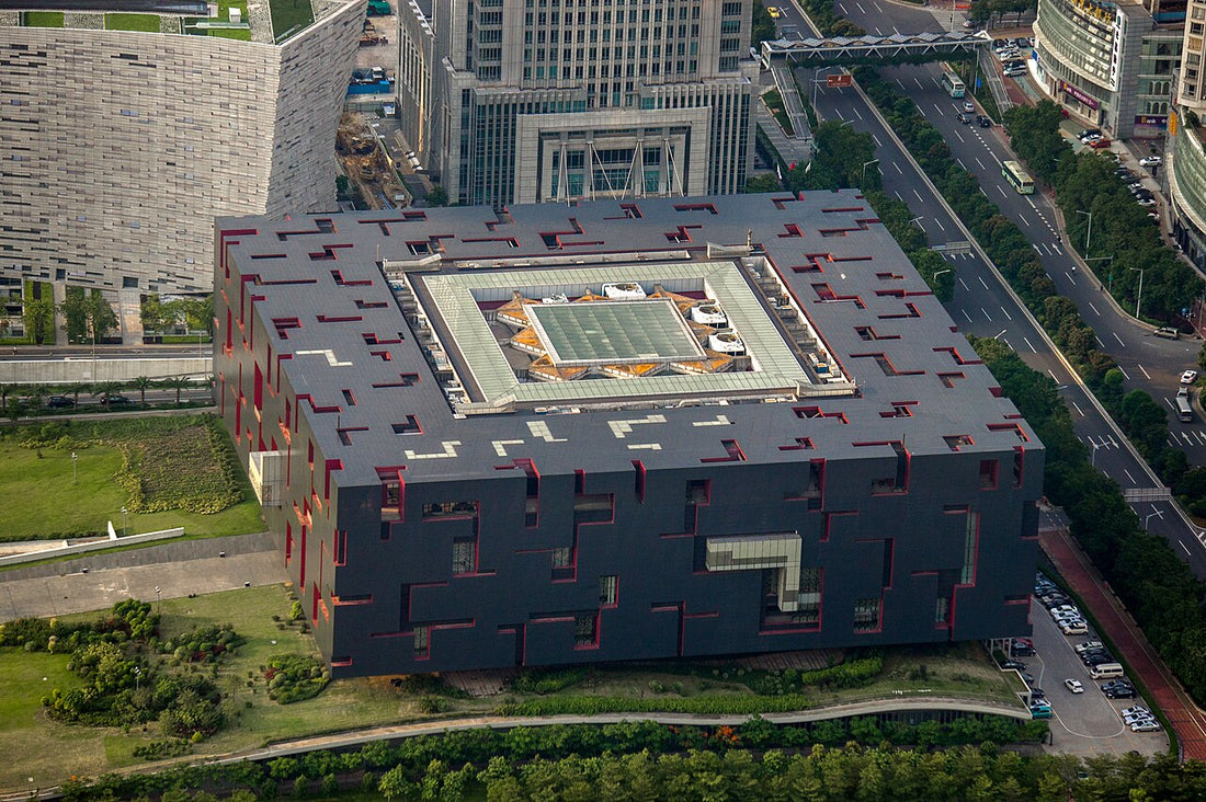 Elevated view of Guangdong Museum's dark geometric building with red recesses in Guangzhou
