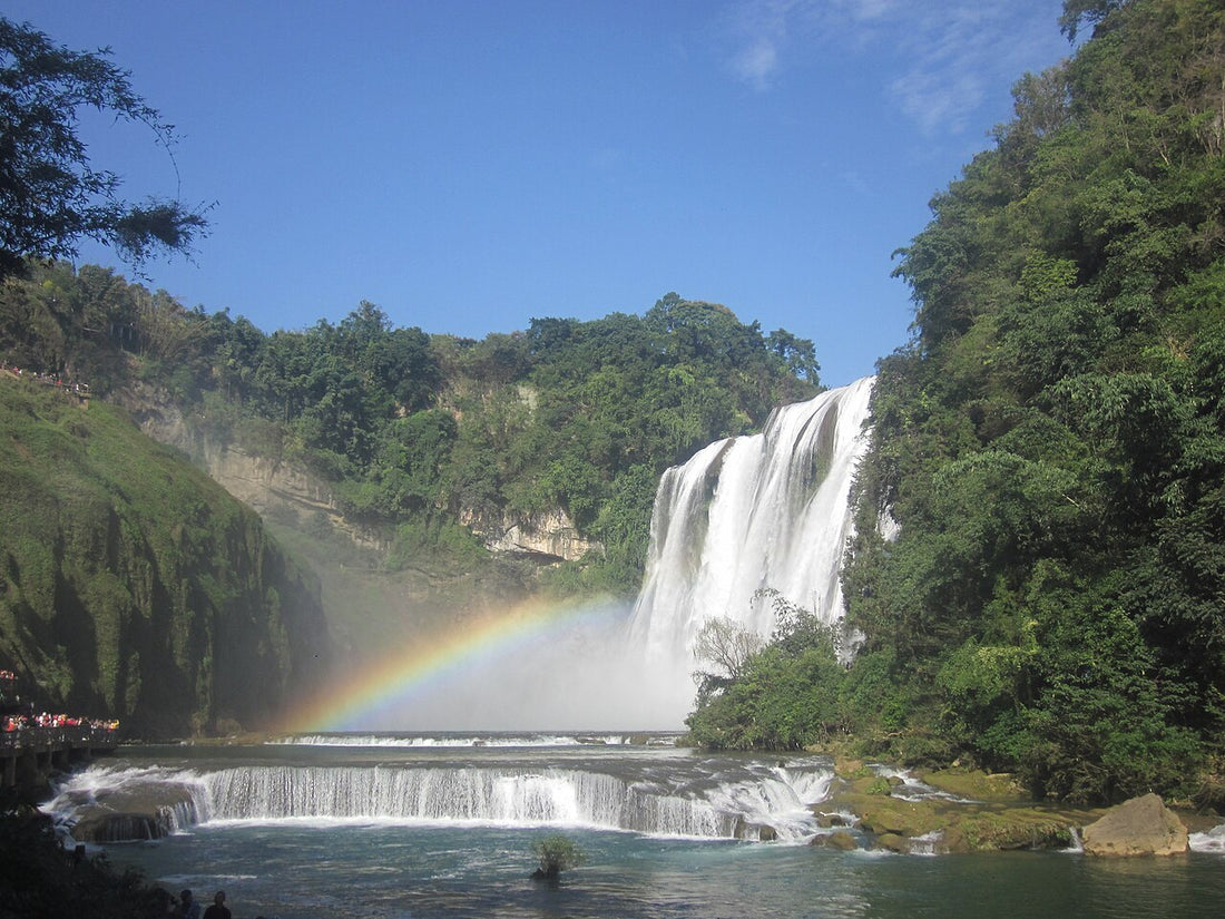 Huangguoshu main waterfall dropping into its basin with a rainbow in the spray