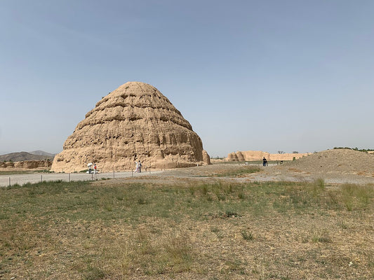 Weathered earthen structure at Western Xia Tomb 3 with visitors on the path
