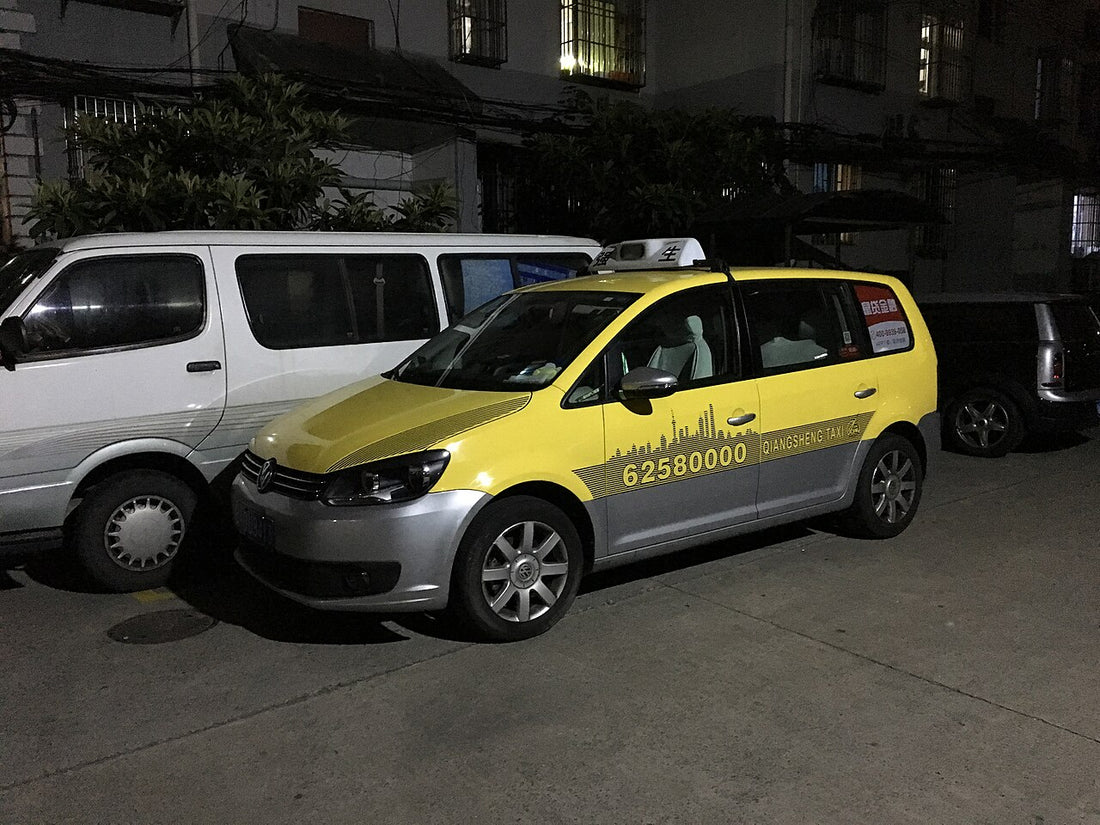 Yellow and grey Shanghai taxi parked at night