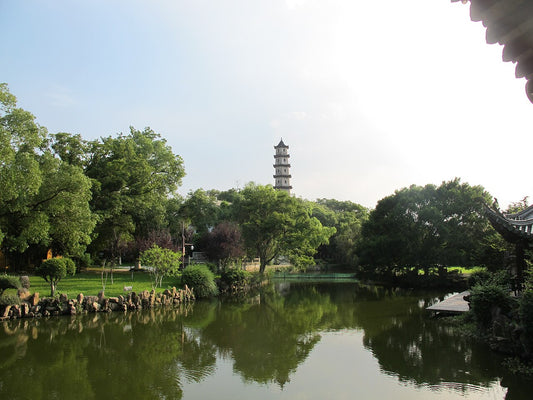 West Pagoda rising above trees and a pond on Jiangxin Island in Wenzhou
