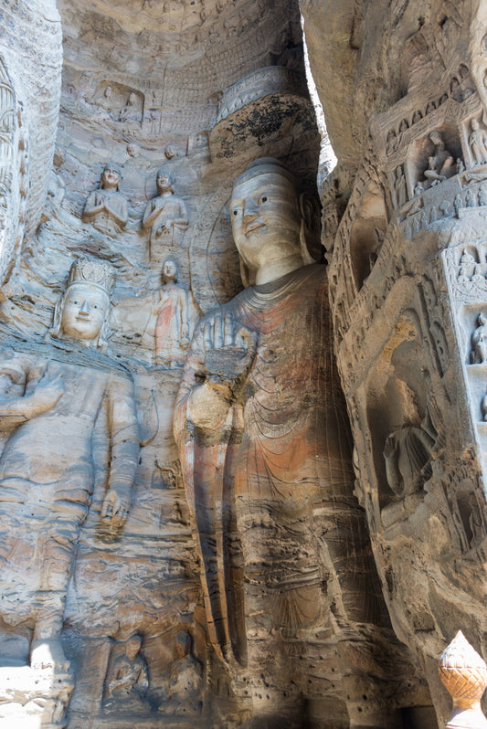 Large Buddhist figure surrounded by smaller carvings at Yungang