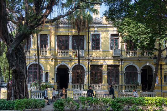 Yellow building with arched windows and mature trees on Guangzhou's Shamian
